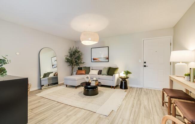 Front door and spacious living room interior including furniture at The Arbor, in Blue Springs, MO