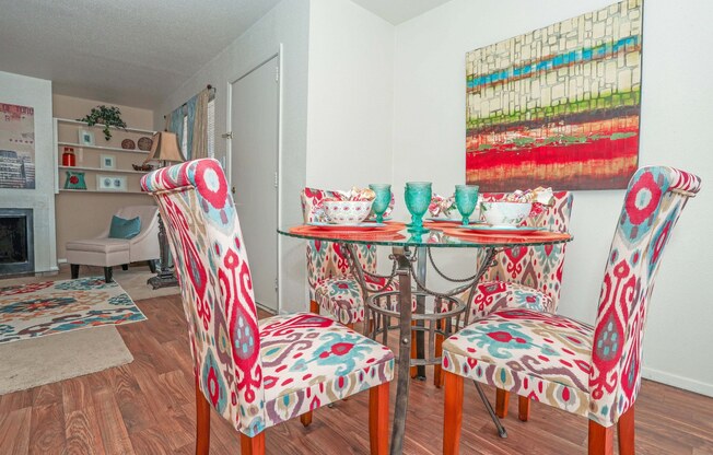A dining room with a table and colorful chairs at Laurel Parc apartments in Shreveport, LA.