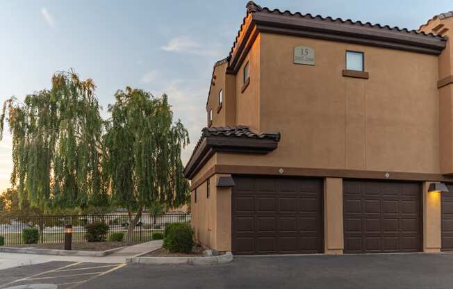 a house with a garage and a weeping willow tree in the background