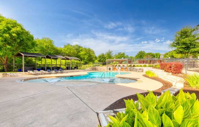 a swimming pool with trees in the background and a blue sky