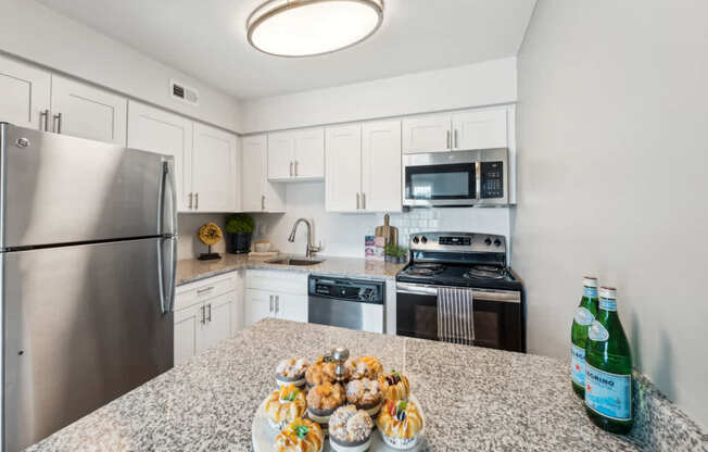 A kitchen with a granite countertop and stainless steel appliances.