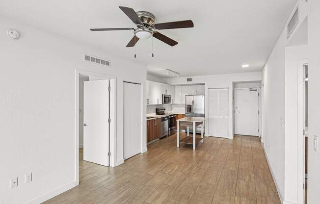 A room with a ceiling fan and wooden floors.