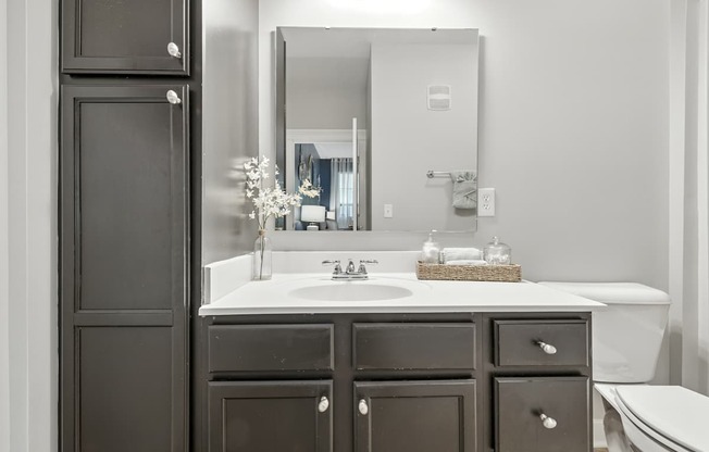 A bathroom with a white sink and a large mirror.