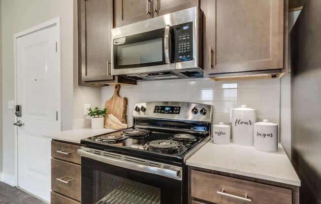a kitchen with a stove top oven next to a microwave