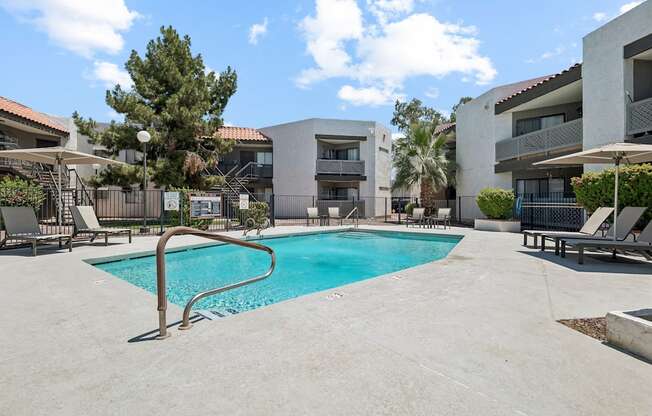 A swimming pool in a residential area surrounded by buildings and trees.