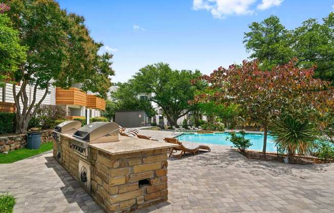 a backyard with a pool and a barbecue grill