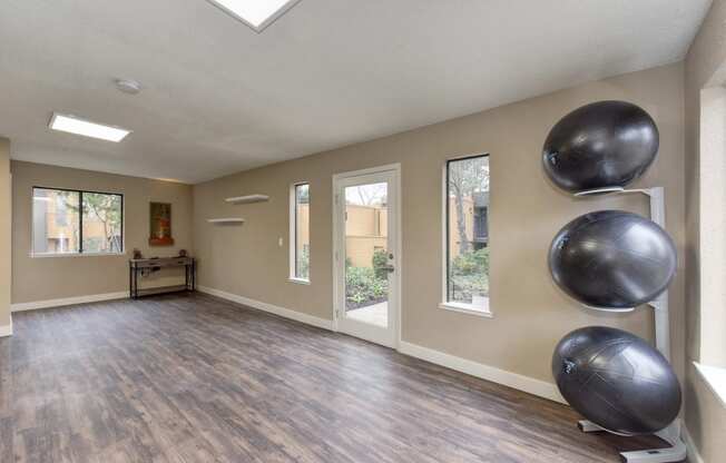 Community Yoga Studio with Hardwood Inspired Floor, Yoga Balls, Large Window and Wicker Basket with Yoga Mats