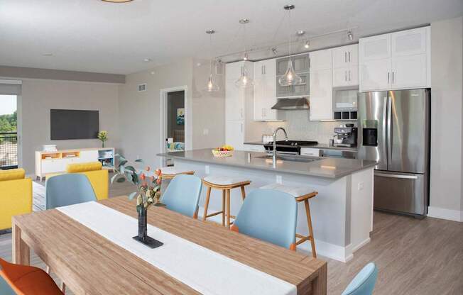 A modern kitchen with a wooden table and blue chairs.
