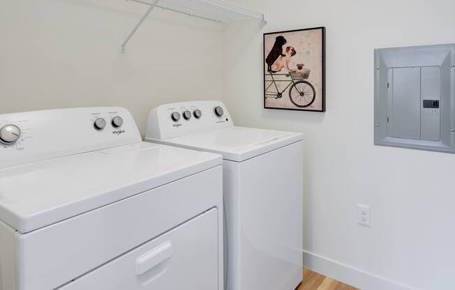 a washer and dryer in a laundry room with a painting on the wall at Statesman Apartments, Wisconsin 53132