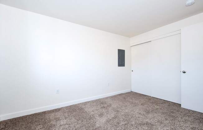 a bedroom with white walls and carpet