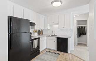 a renovated kitchen with black appliances and white cabinets at Rosemont Square Apartments, Randolph