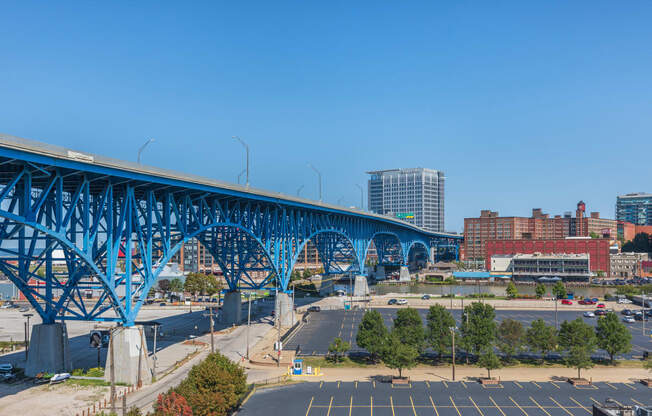 a bridge over a parking lot with a city in the background