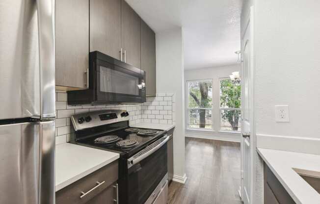 an empty kitchen with a stove and a microwave