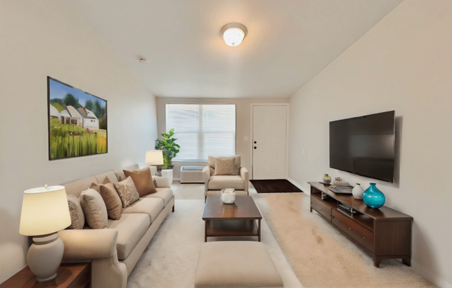 A living room with a beige sofa, a coffee table, and a flat screen TV.