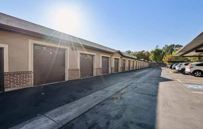 a row of garages and cars parked outside of a building