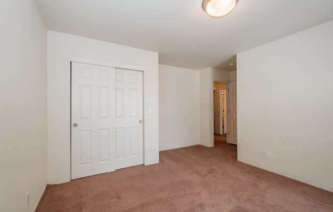 a bedroom with a carpeted floor and a white door