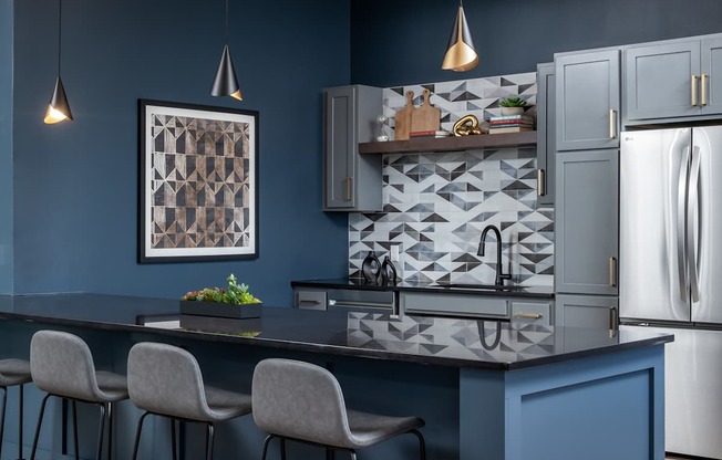 A kitchen with a dark blue theme and a modern design.