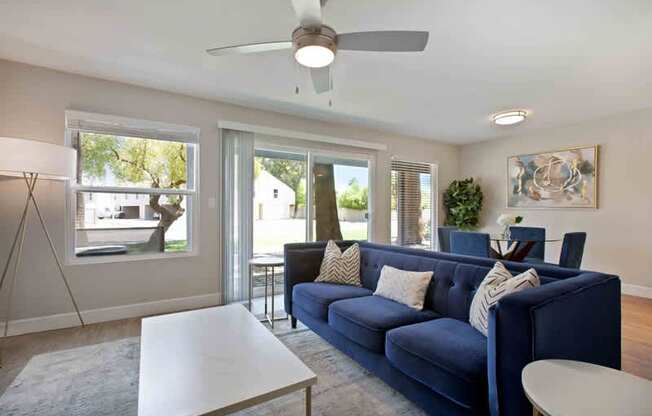 A living room with a blue couch and a white coffee table.