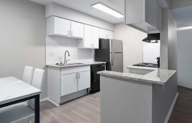 a kitchen and dining room with white cabinets and a stainless steel refrigerator