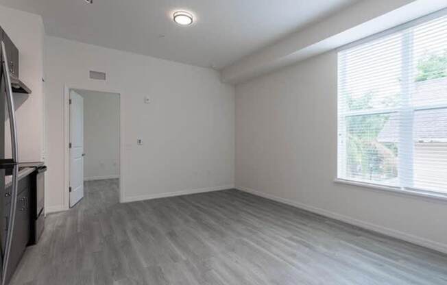 A spacious room with a grey floor and white walls.
