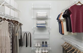 A walk in closet with wardrobe organizers at The Highlands Apartments in Elkhart, IN