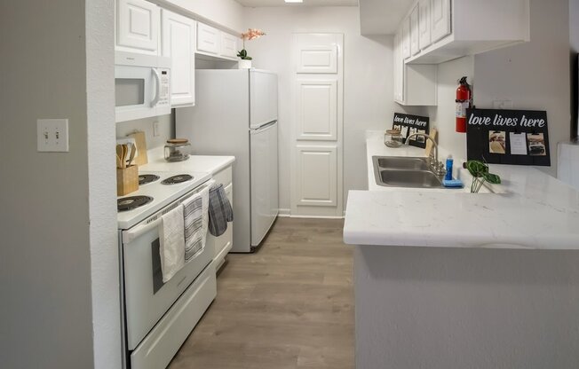 a kitchen with white appliances and white cabinets