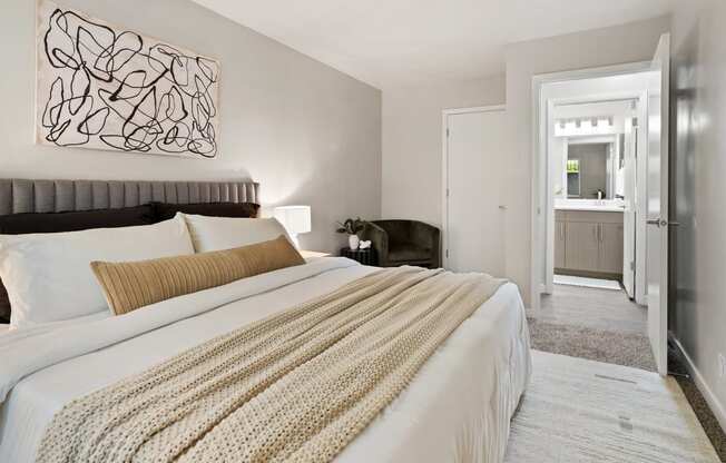 The Grove Apartments bedroom with large bed and nightstands and bathroom
