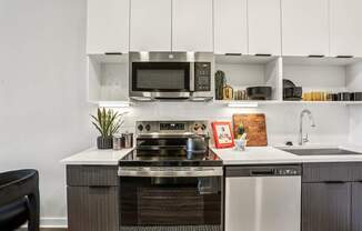 A modern kitchen with a stove top oven and microwave above it.