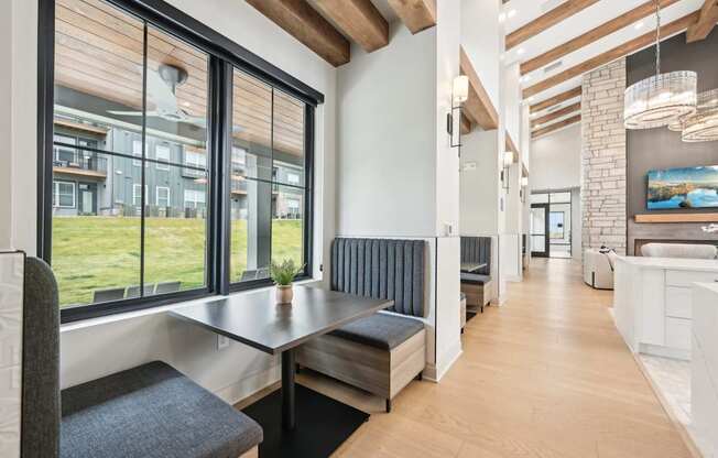 a dining room with a table and chairs and a wall of windows