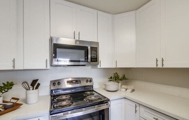 a kitchen with white cabinets and stainless steel appliances