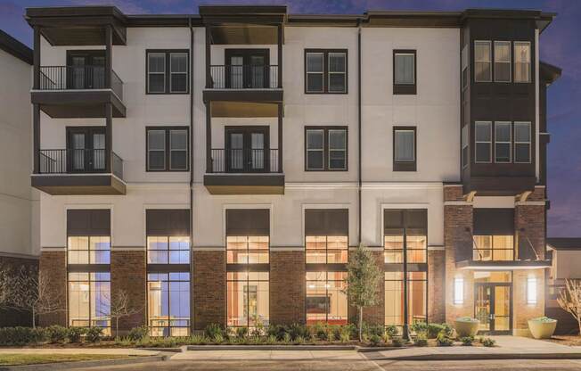 A modern apartment building with balconies and large windows.