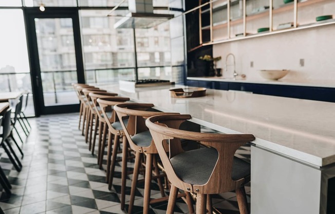 a row of bar stools in a restaurant with a white counter top and a at The Lively, New Jersey