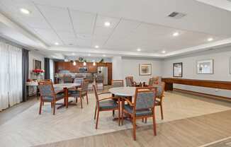 a dining room with tables and chairs and a kitchen