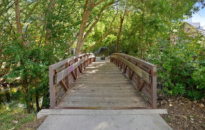 a wooden bridge over a river with trees on both sides