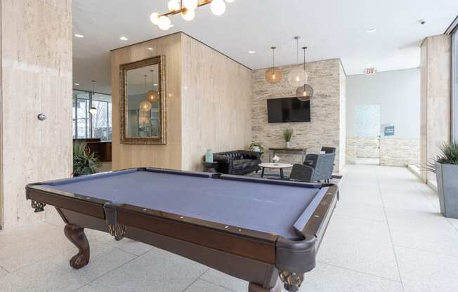 a pool table in the lobby of an office with a tv