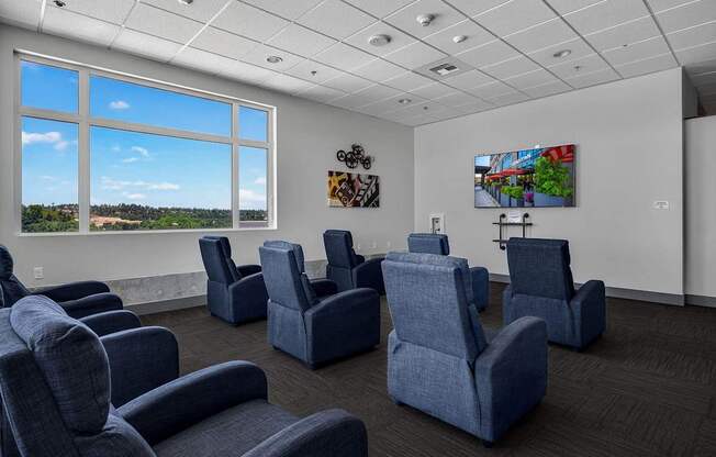 A room with blue chairs and a painting on the wall.