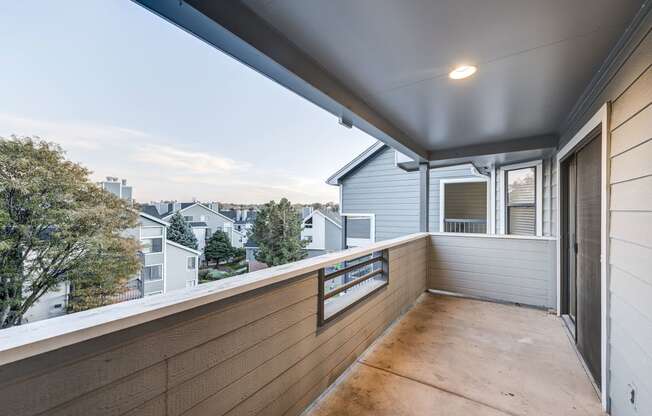 a balcony with a wood floor and a view of a city at Ashford Belmar Apartments, Lakewood, 80226