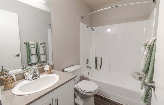 A white bathroom with a toilet, sink, and bathtub.