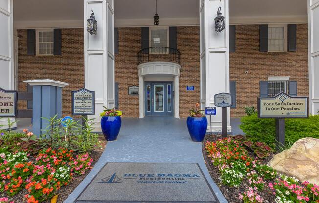 a close up of a flower garden in front of a brick building