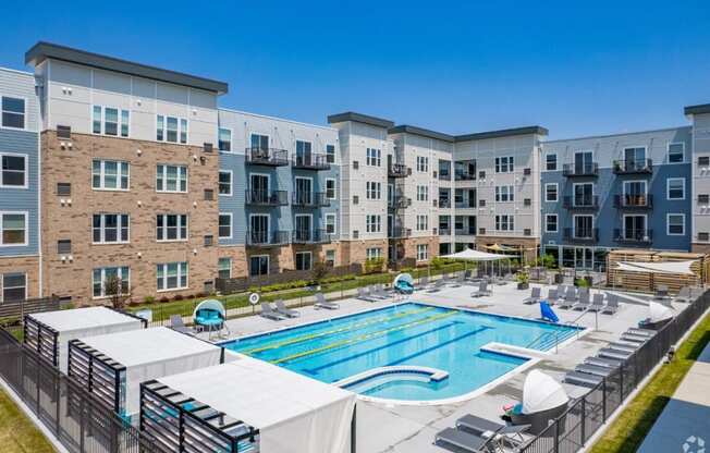 an outdoor swimming pool with an apartment building in the background