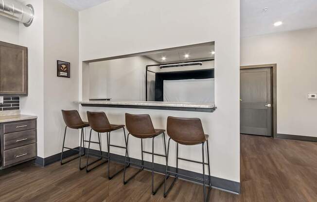 Three brown leather bar stools are placed in front of a mirror.