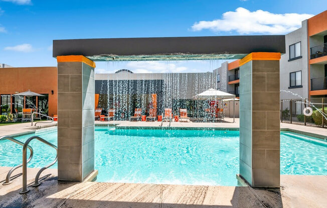 Community Swimming Pool with Waterfall at Harmony at Surprise Apartments in Surprise, AZ.