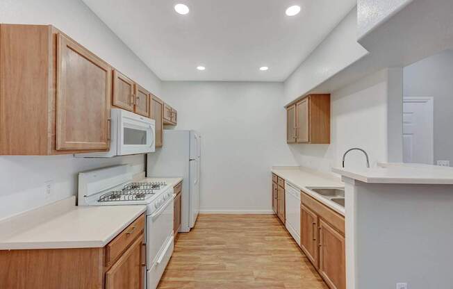 A kitchen with wooden cabinets and white appliances.