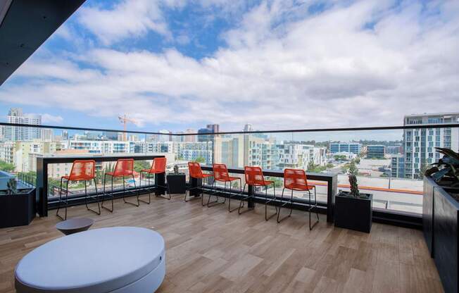 a view of a city from a balcony with chairs and a table
