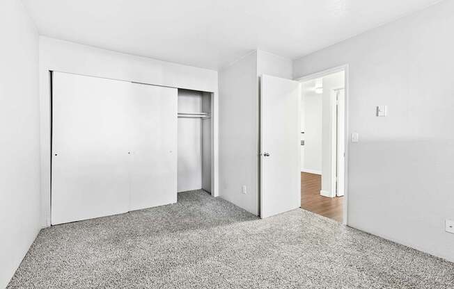 A room with a grey carpet and white walls.