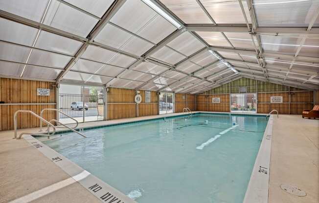 a indoor swimming pool in a building with a glass ceiling