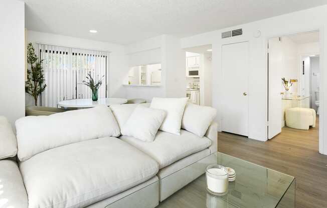 a living room with a white couch and a glass table