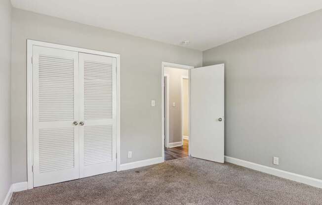 A room with a white door and a carpeted floor.