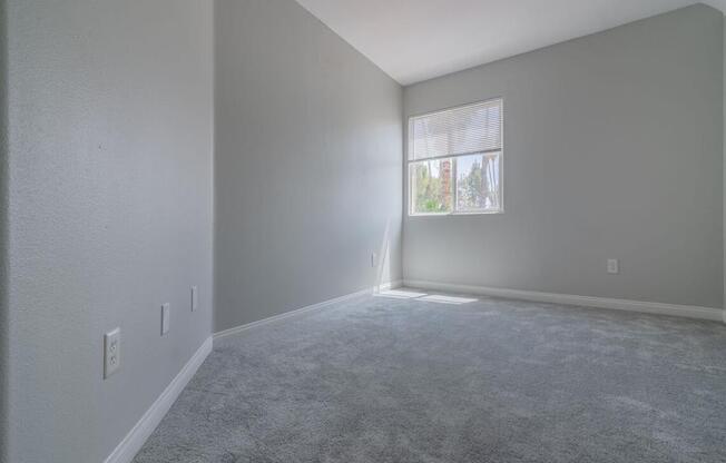 an empty living room with a window and carpet at Warner Center Townhomes, Canoga Park, CA 