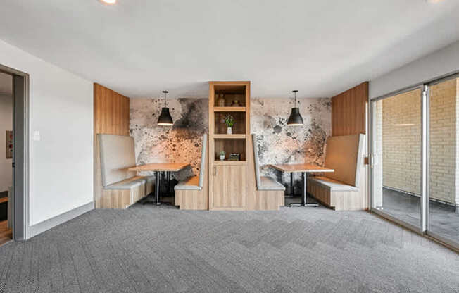 A room with a grey carpet and a wooden bookshelf.
